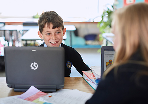Boy using HP laptop in class