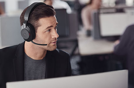 Man wearing black Evolve2 85 headphones taking a call
