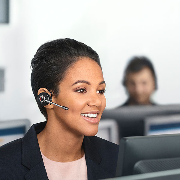 Woman wearing Jabra Engage wireless headset at computer