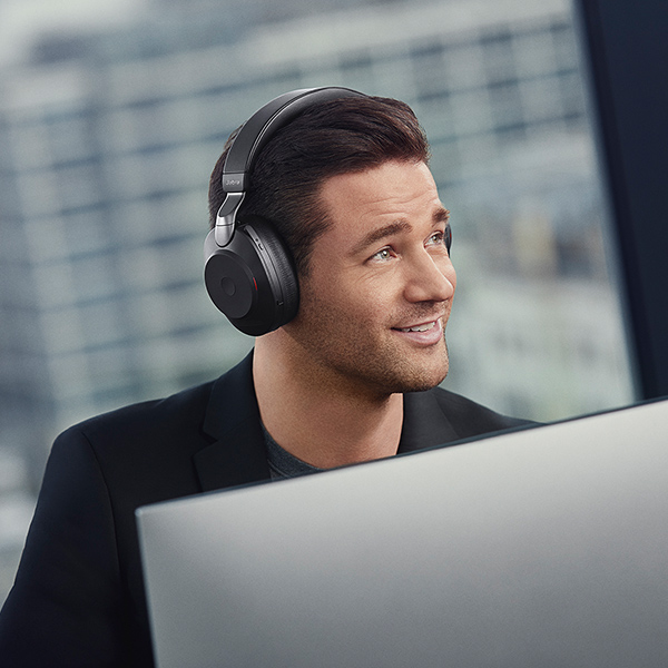 Man wearing Jabra Evolve2 headsphones at desk