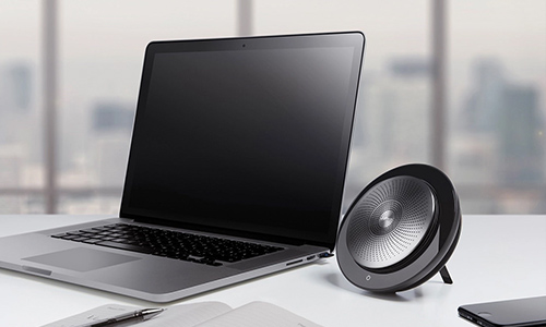 Jabra Speak portable speaker next to a laptop