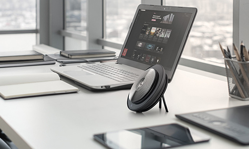 Jabra Speak portable speaker on desk with a laptop