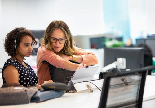 Two women looking at business apps on a Windows 10 pro device