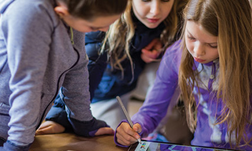 Three girls using surface device and pen