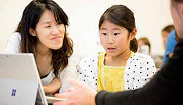 Student and teacher using surface device in classroom