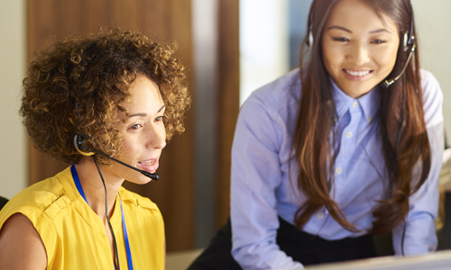 Two women with headsets providing IT support