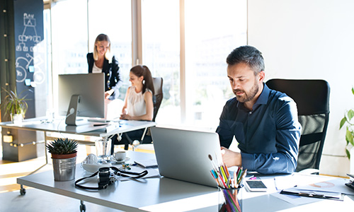 Man on laptop using office applications