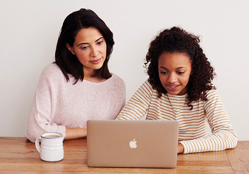 Parent and child working on laptop