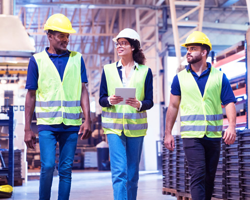 Workers in hard hats and hi-vis vests in a warehouse