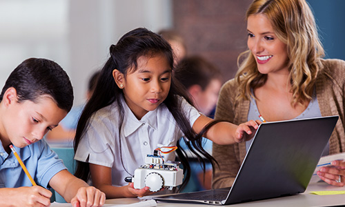 young students using AMD devices to code robots