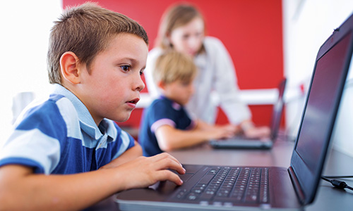 young male student using Lenovo laptop in classroom