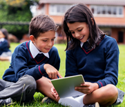 School Children using a tablet device outside