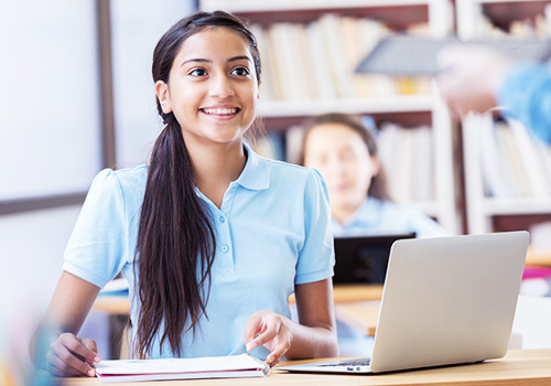 Female student using mobile device in classroom