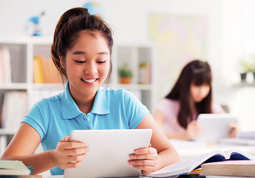 Female student using mobile device in classroom